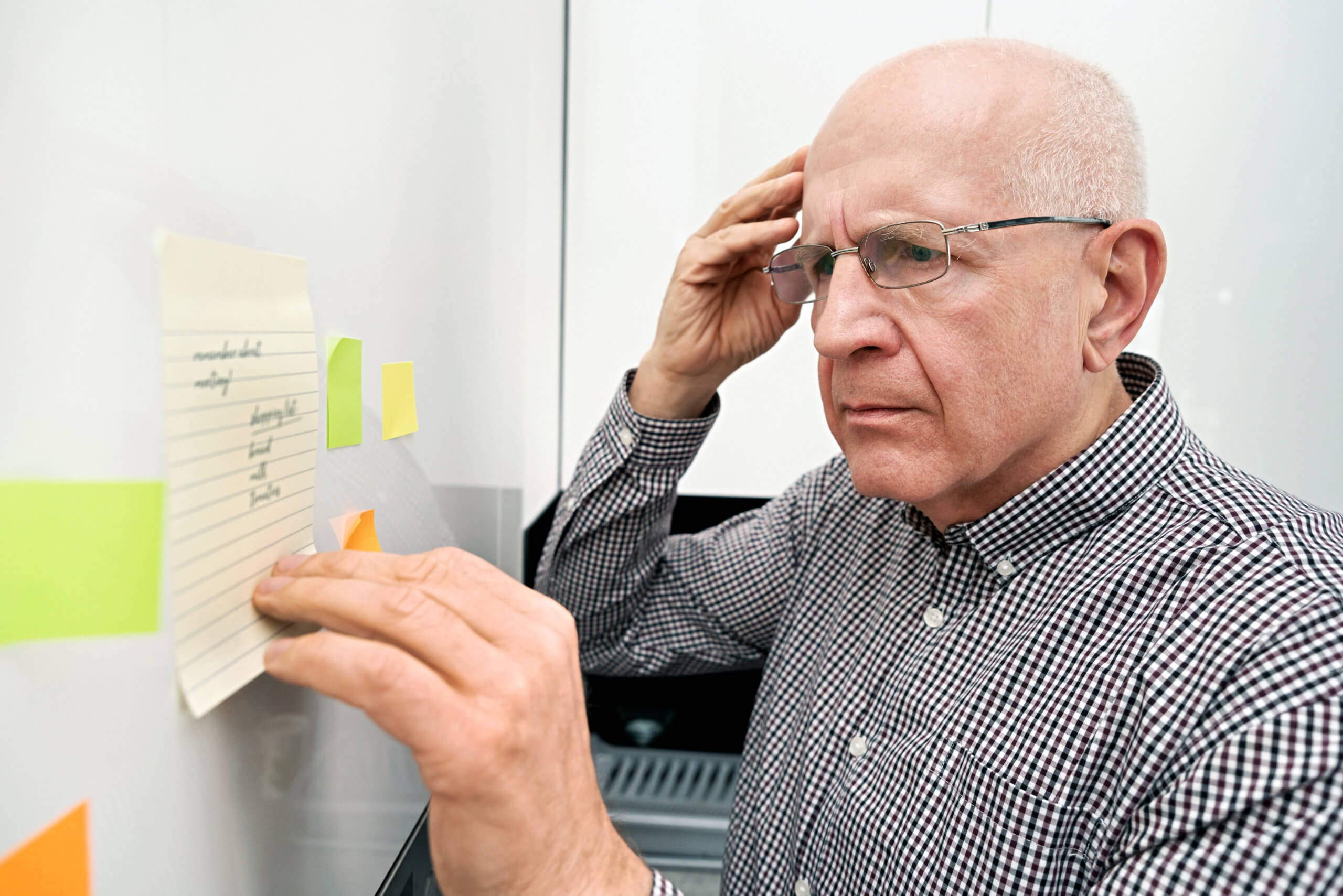 Elderly man with dementia looking at notes Memory Boosting Vitamins and Minerals For Seniors