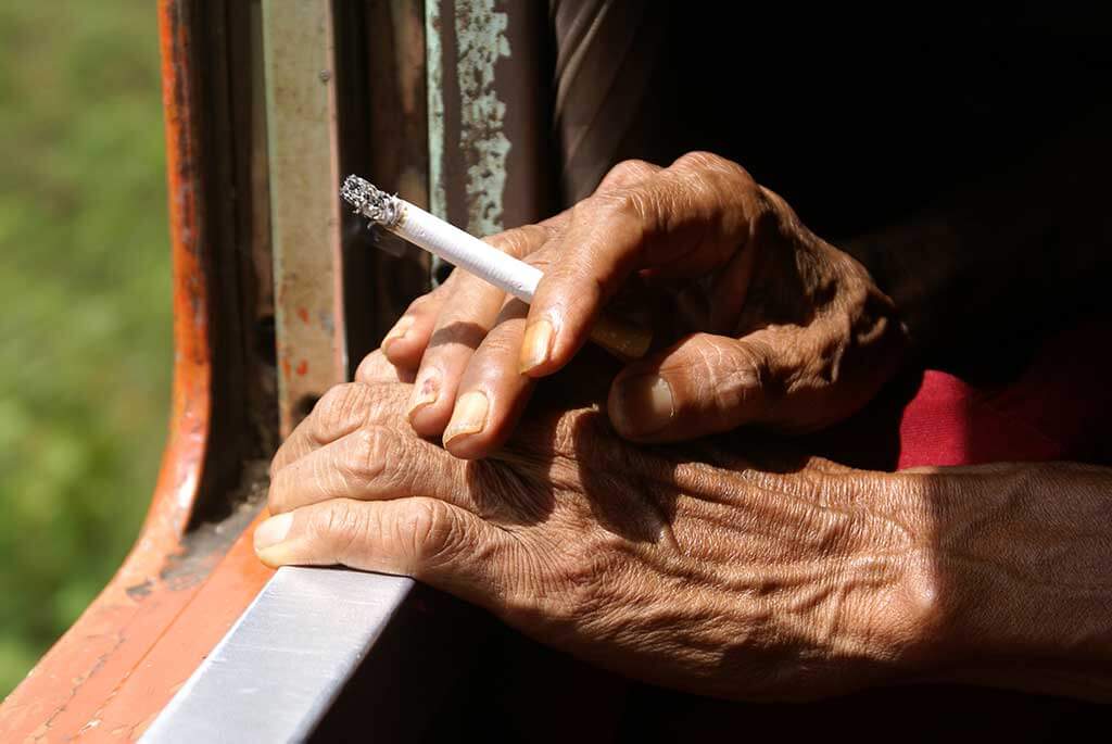Hand with cigarete on the window in train