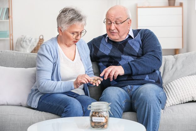 Senior couple counting money at home