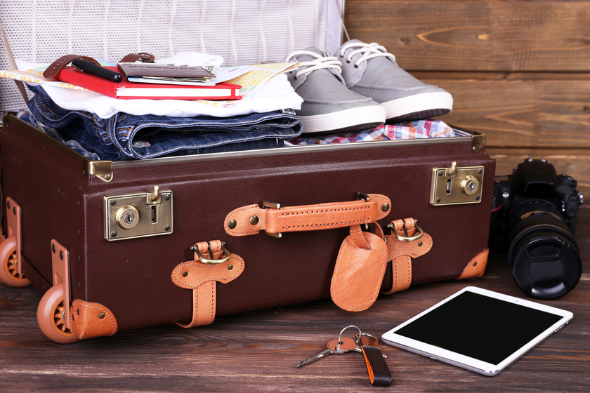 Packed suitcase of vacation items on wooden background Moving To 55+ Community In Columbus, IN: Understanding What You Should Bring