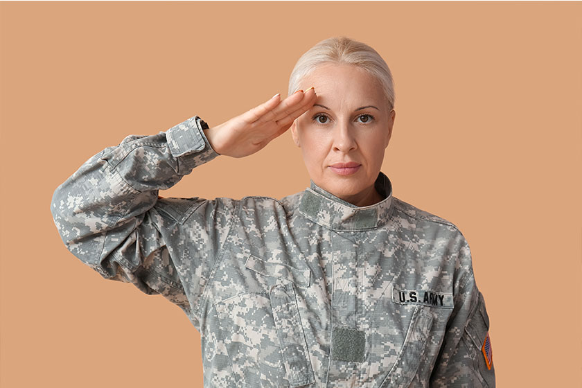 Mature female soldier saluting on beige Mature female soldier saluting on beige