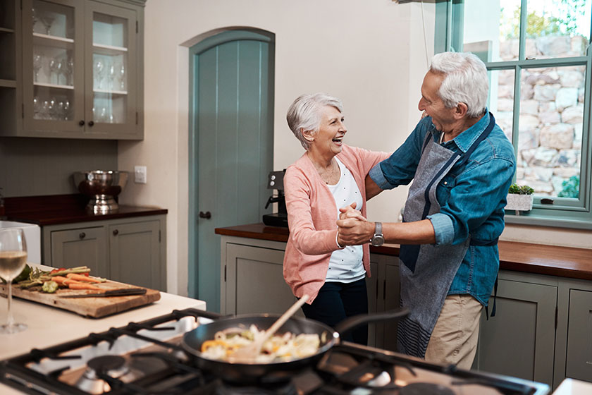 We know how to keep our love going strong. a senior couple dancing while cooking in the kitchen at home We know how to keep our love going strong. a senior couple dancing while cooking in the kitchen at home