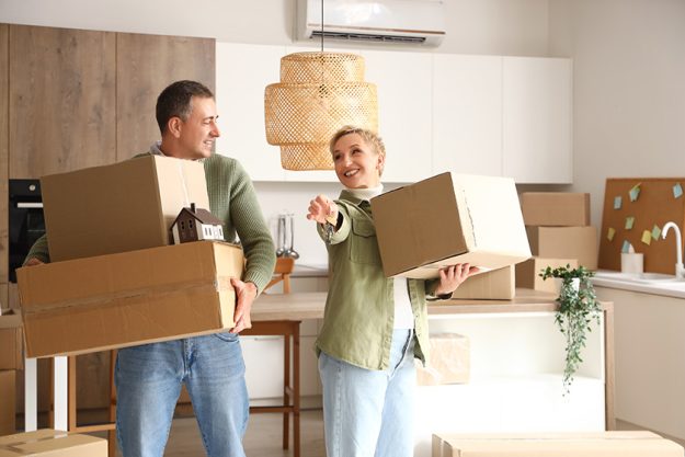 Mature-couple-with-cardboard-boxes-and-keys. Mature-couple-with-cardboard-boxes-and-keys.