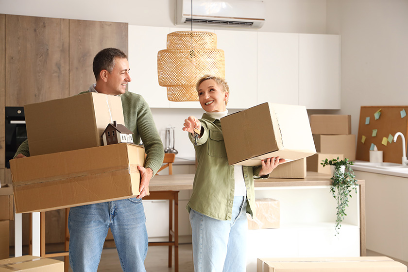 Mature-couple-with-cardboard-boxes-and-keys. Mature-couple-with-cardboard-boxes-and-keys.