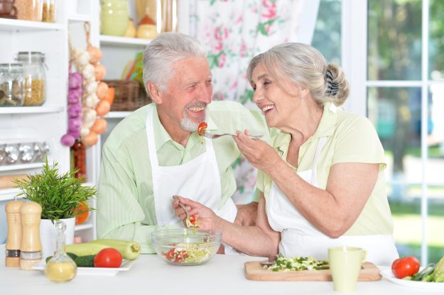 Portrait of a senior couple cooking in kitchen