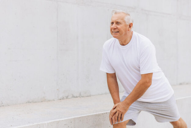 Senior Man Stretching Outdoors in Sportswear for Fitness Routine